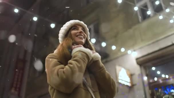 Sorrindo menina durante a queda de neve à noite — Vídeo de Stock