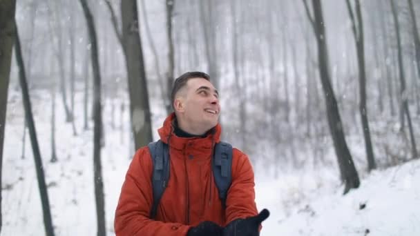 Человек, гуляющий в лесу во время снегопада — стоковое видео