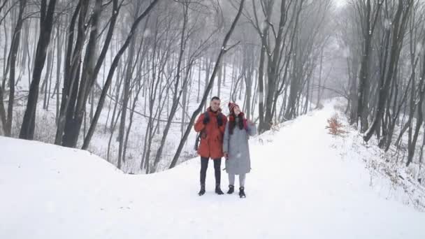 Pár uprostřed lesa těší sněžení — Stock video