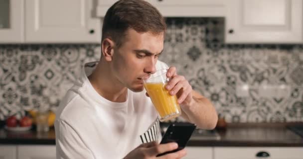 スマート フォンを使用している間人を飲むジュース — ストック動画
