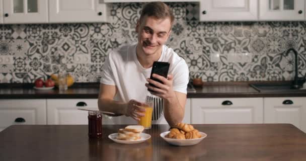 Homme dans Cuisine Navigation sur Smartphone — Video