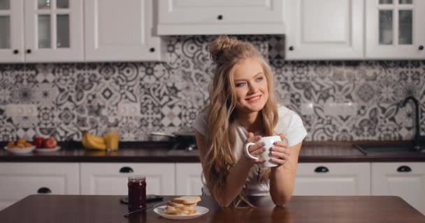 Schönes Mädchen trinkt Kaffee in der Küche — Stockvideo