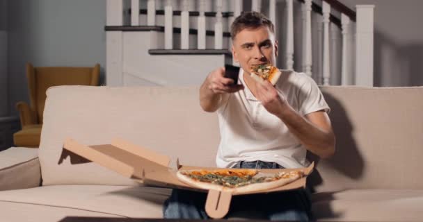 Ontspannen Man eten Pizza en Tv kijken — Stockvideo