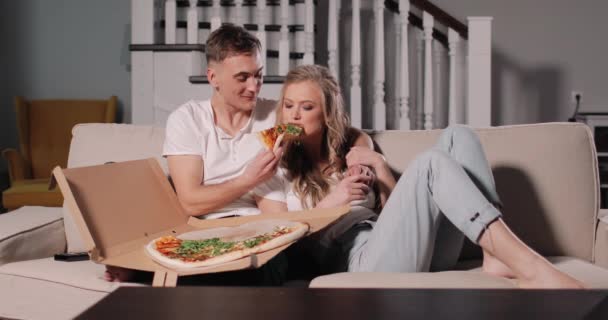 Relajante pareja enamorada compartiendo rebanada de pizza — Vídeos de Stock