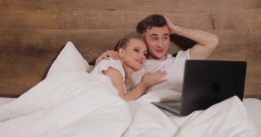 Dizüstü bilgisayar Video izlerken yatakta yalan Çift