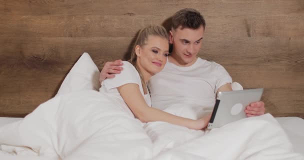 在床上使用平板电脑的放松夫妇 — 图库视频影像
