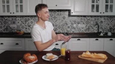 Suyu içme ve tablet kullanarak Internet'e gözatmak genç adam