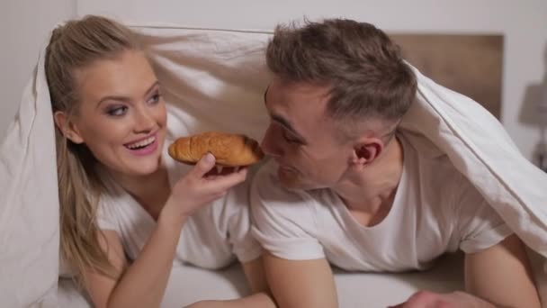 Compartilhamento de casais Croissant na cama — Vídeo de Stock