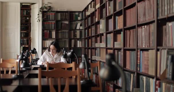 Широкий знімок дівчини в бібліотеці — стокове відео
