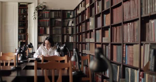 Amplo tiro de menina estudando na biblioteca — Vídeo de Stock