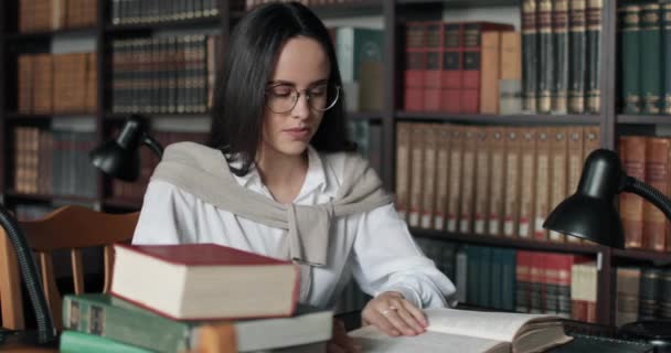 Κουρασμένος κορίτσι σπουδάζει στη βιβλιοθήκη — Αρχείο Βίντεο
