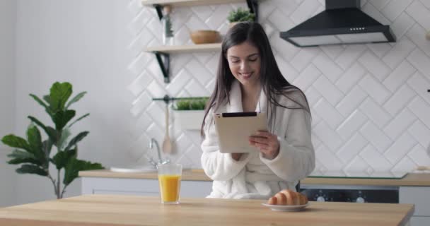 Boldog lány tabletta használata a konyhában — Stock videók