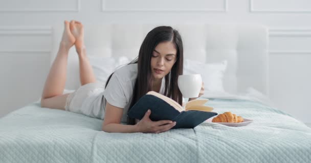 Chica disfrutando de la lectura mientras bebe café — Vídeo de stock