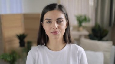 Evde gülümseyen genç bir kadın 