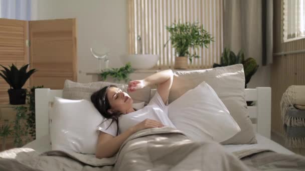 Despertando chica sonriendo en la cama — Vídeo de stock