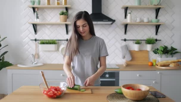 Gelukkig meisje snijden groenten in de keuken — Stockvideo