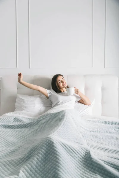 Mujer estirándose en la cama — Foto de Stock