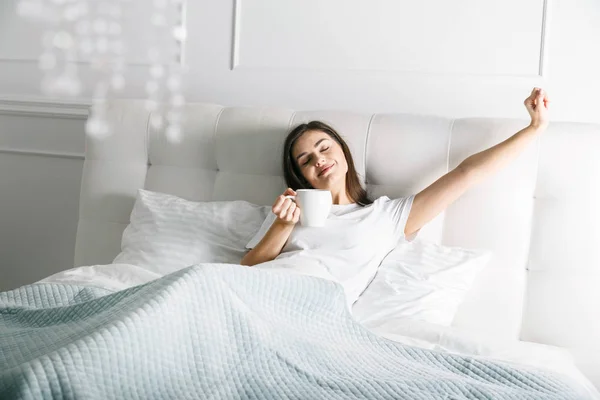 Mujer estirándose en la cama —  Fotos de Stock