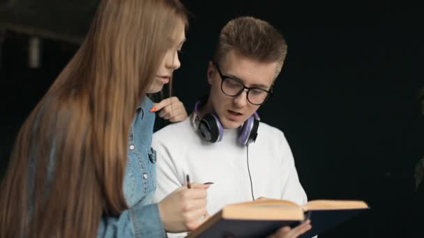 Jonge studenten onder discussie over notities — Stockvideo