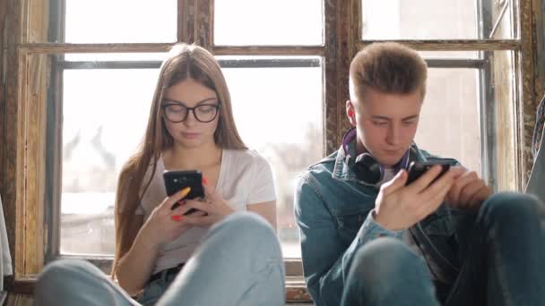 Pareja joven usando teléfonos inteligentes — Vídeo de stock