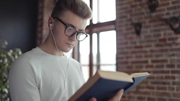 Studente serio che legge mentre ascolta le canzoni — Video Stock