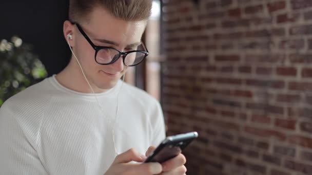 Jonge jongen SMS op zijn smartphone — Stockvideo