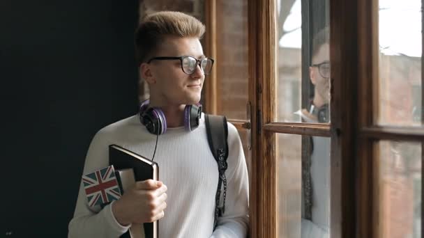 Estudante segurando a bandeira de Great Britains e em pé junto à janela — Vídeo de Stock