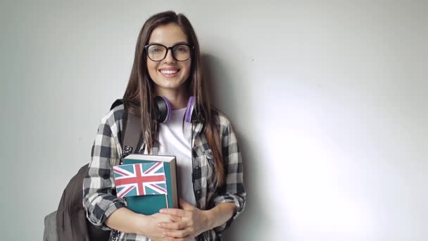 Ragazza che tiene borsa e libri con grande bandiera britannica — Video Stock