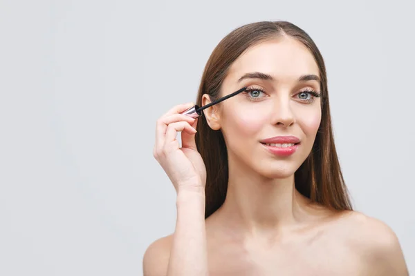 Donna che applica Mascara — Foto Stock