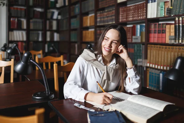 Vrouwelijke student studeert in bibliotheek — Stockfoto