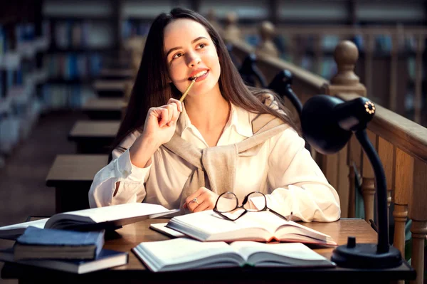 Student zitten in de bibliotheek — Stockfoto