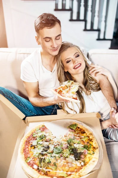 Pareja comiendo pizza en el sofá —  Fotos de Stock