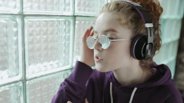 Jong meisje geniet van het luisteren naar muziek via de koptelefoon — Stockvideo