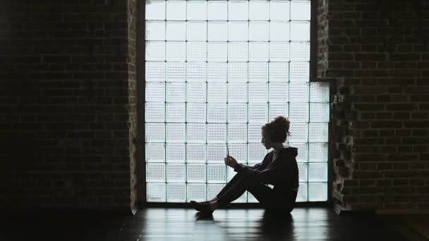 Mladá dívka sedí na podlaze a poslechu hudby — Stock video