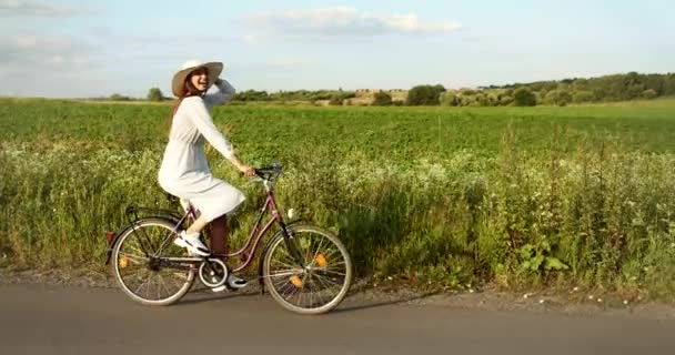 Feliz mulher equitação bicicleta no país estrada — Vídeo de Stock