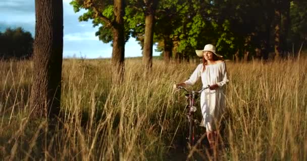 Mujer caminando con bicicleta en el campo — Vídeo de stock