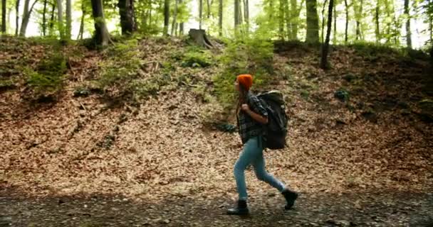 Visão lateral da mulher com mochila na floresta — Vídeo de Stock