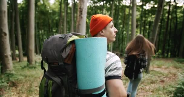 Paar backpacked toeristen wandelen in het bos — Stockvideo