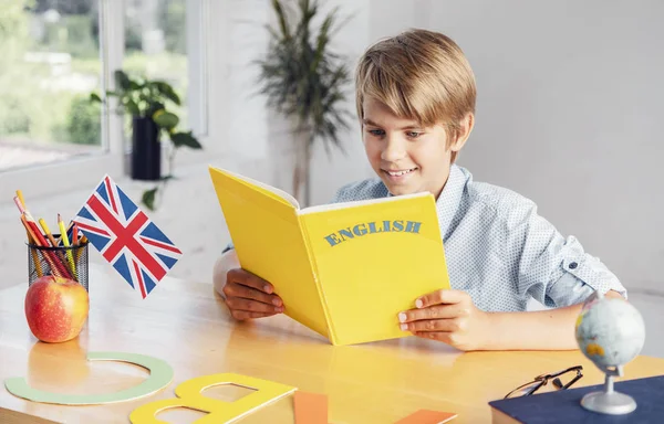 Мальчик, читающий английскую книгу — стоковое фото