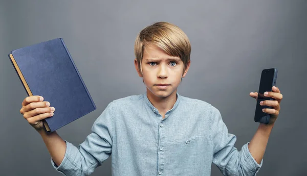 Pojke Tvivling bok eller smartphone — Stockfoto