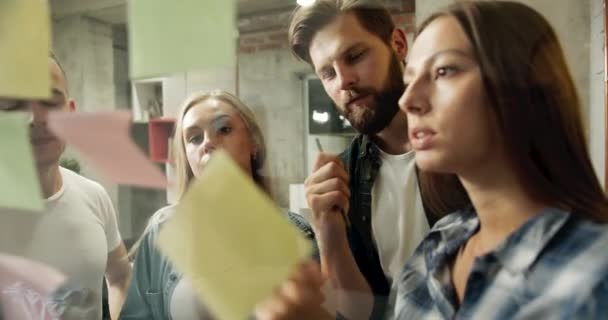 Team sätta klistermärken på glasvägg brainstorming — Stockvideo