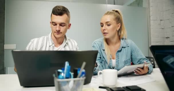 Office-collega's die op een laptop werken — Stockvideo