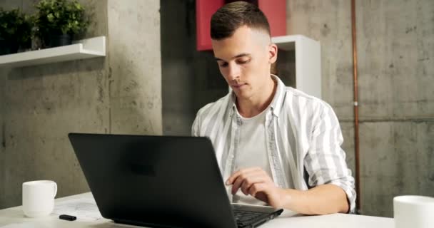 Hombre trabajando en el ordenador portátil en la oficina — Vídeos de Stock