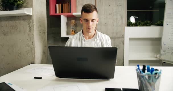 Hombre trabajando en el ordenador portátil en la oficina — Vídeo de stock