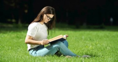 Park yerinde kitap okuyan bir kadın.