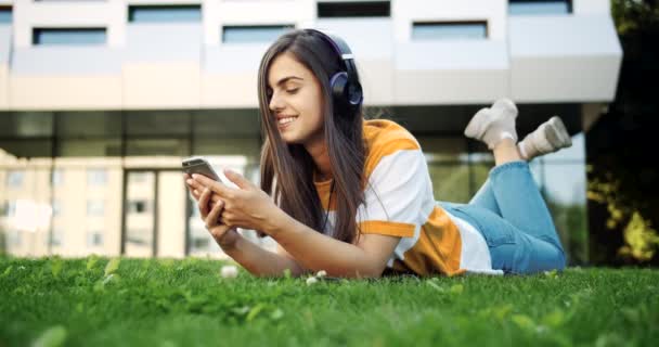 Mulher ouvindo música em fones de ouvido ao ar livre — Vídeo de Stock