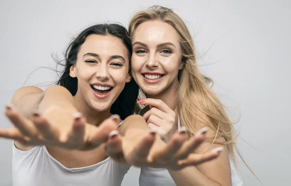 Glada flickvänner sträcker händerna till kameran — Stockfoto