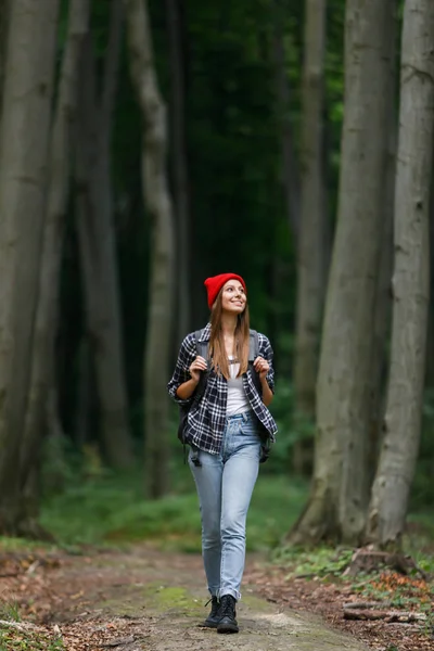 Mulher caminhando através da floresta verde — Fotografia de Stock