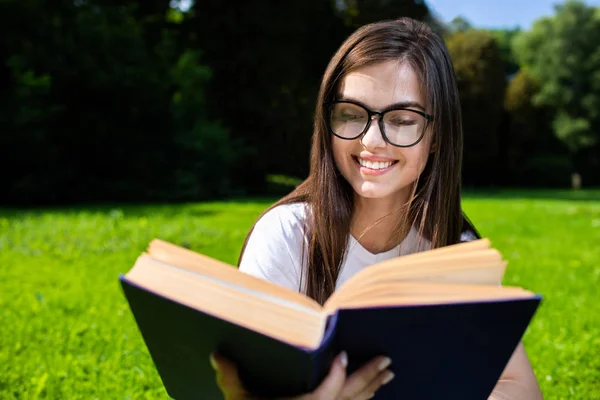 Bastante morena chica leyendo en parque — Foto de Stock