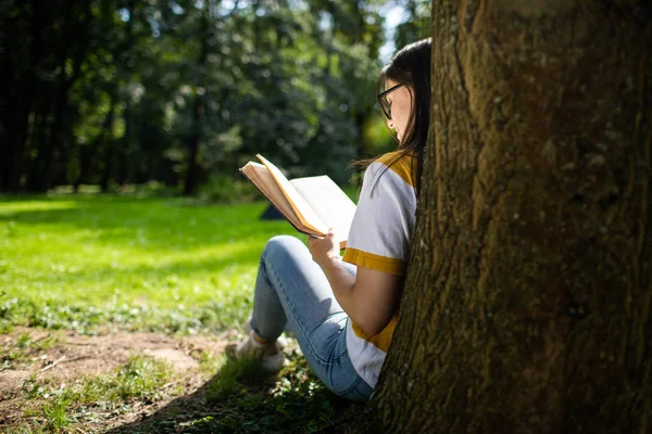 年轻女子阅读公园景观从后面 — 图库照片